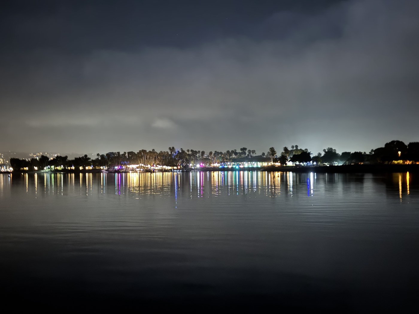 Mission Bay at dusk with the lights of the shore reflected on the water